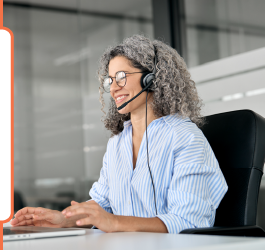 An image of someone with a headset, working at a laptop