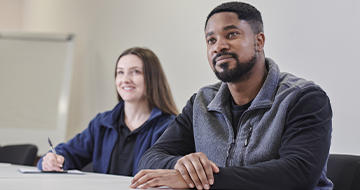 Image of two people sat at a desk